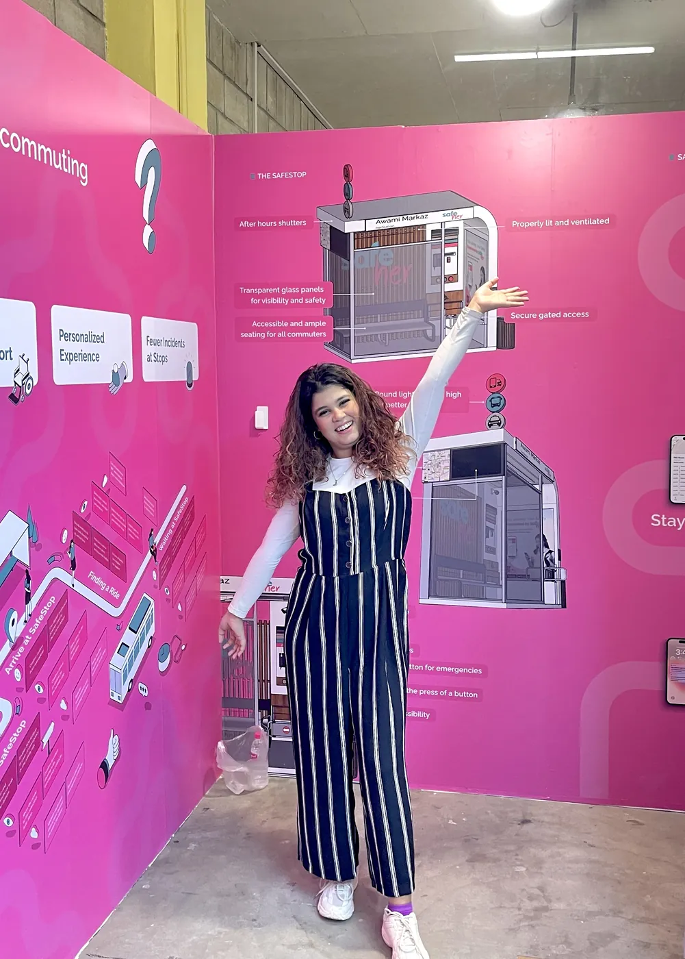Nabia presenting the SafeHer exhibition wall, which sets out the SafeStop anatomy and the companion app.