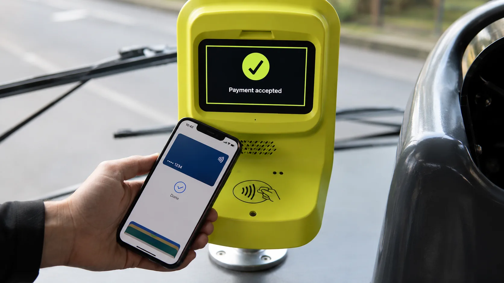 Reference image: a hand tapping a phone on a yellow transit fare reader that reads Payment accepted.